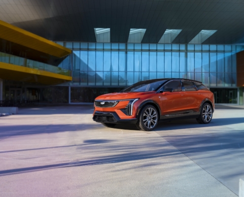 A front 3/4 view of the 2025 Cadillac OPTIQ in Monarch Orange.