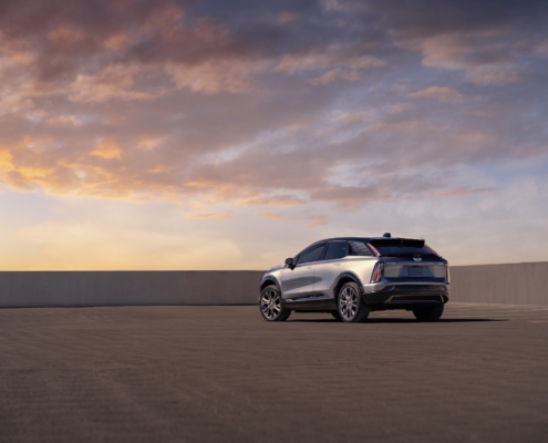 Rear 3/4 view of 2025 Cadillac OPTIQ in Argent Silver Metallic.