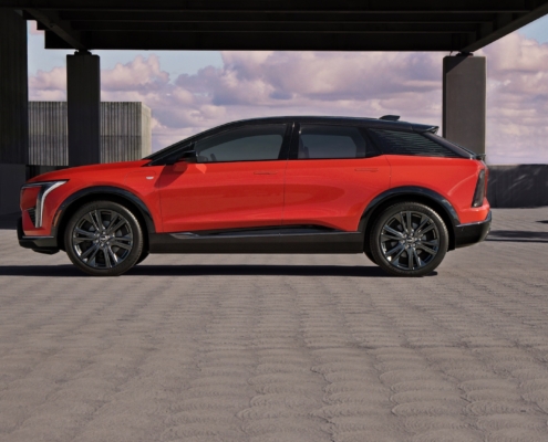 Side profile view of 2025 Cadillac OPTIQ in Monarch Orange.